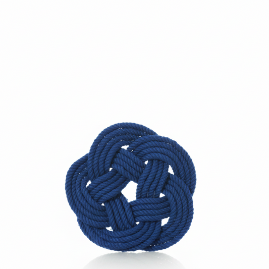 A set of four Nautical Sailor Knot Coasters Cobalt by true is displayed against a plain white background, each featuring a neatly tied blue Turk’s head knot in a round, intricate pattern with a subtle reflection below.