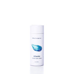 A white tube labeled “Atlantic Eco-Friendly Body Balm Stick” by Shore Soap Co., featuring a blue shell illustration on the front and containing 2 ounces, is centered on a white background. This concentrated moisturizer provides hydration for dry skin while serving as an eco-friendly body balm choice.