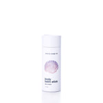A white cylindrical container labeled Shore Soap Co Warm Sand Eco-Friendly Body Balm Stick, featuring a pink seashell graphic on the front, stands on a white background; this concentrated body balm delivers lasting hydration for your skin.