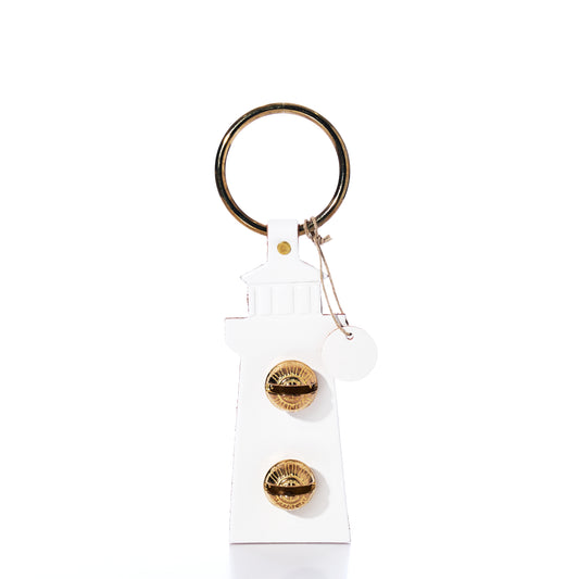 A White Lighthouse Door Chime keychain from true, featuring a gold keyring and two gold dials on the front, reminiscent of a New England Bells lighthouse door chime, photographed against a white background.