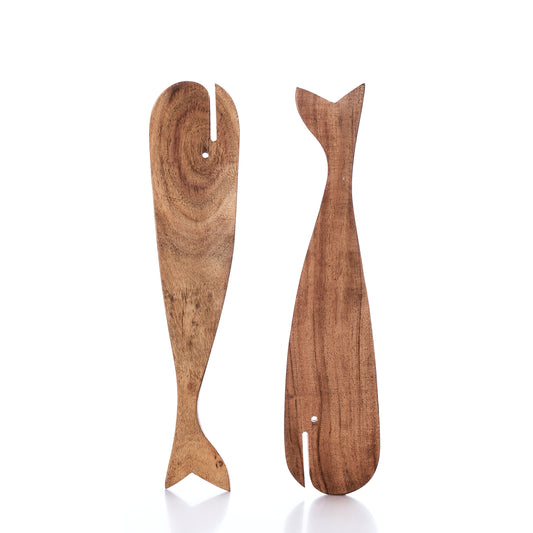 The Salad Server Set - Wood Whales by Batela USA Inc features two wooden utensils crafted in the shape of whale tails, shown standing upright on a white background. These wooden servers add coastal charm and a subtle nautical touch to any kitchen or dining table. by Sea Bags