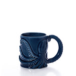 The Blue Octopus Mug by Batela USA Inc is a dark blue nautical mug with an embossed octopus design and a tentacle-shaped handle, displayed against a white background. by Sea Bags