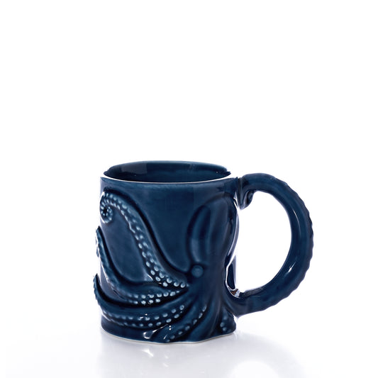 The Blue Octopus Mug by Batela USA Inc is a dark blue nautical mug with an embossed octopus design and a tentacle-shaped handle, displayed against a white background. by Sea Bags