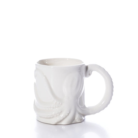 The White Octopus Mug by Batela USA Inc is a white ceramic mug with a raised octopus design, featuring one tentacle as the handle, and is shown against a plain white background. by Sea Bags