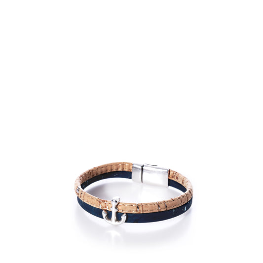 The Classic Cork Bracelet Anchor on Navy by Elisabetta Studio features a Portuguese cork band with a brown base, accented by a navy strip, an antique silver anchor charm, and a nickel-free magnetic clasp, displayed on a white background. by Sea Bags