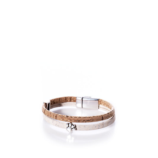 The Classic Cork Bracelet Paw on White by Elisabetta Studio features beige and white Portuguese cork, a small silver paw charm, and a magnetic clasp, shown against a white background. by Sea Bags