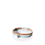 The Classic Cork Bracelet Sea Turtle on Mint Green by Elisabetta Studio features stylish mint green and natural cork bands, accented with a silver sea turtle charm and a sleek silver magnetic clasp, displayed on a white background. by Sea Bags