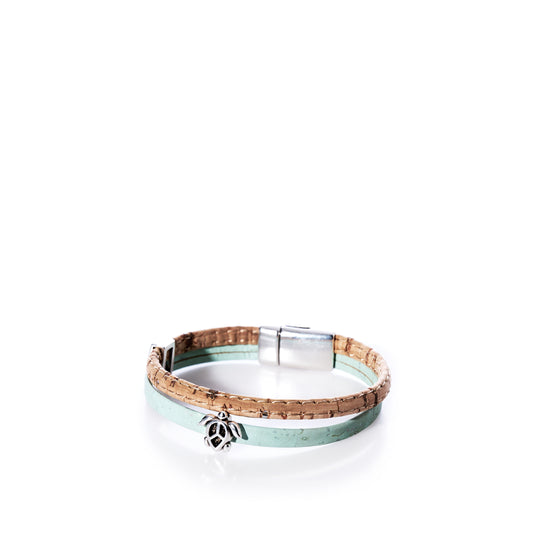The Classic Cork Bracelet Sea Turtle on Mint Green by Elisabetta Studio features stylish mint green and natural cork bands, accented with a silver sea turtle charm and a sleek silver magnetic clasp, displayed on a white background. by Sea Bags