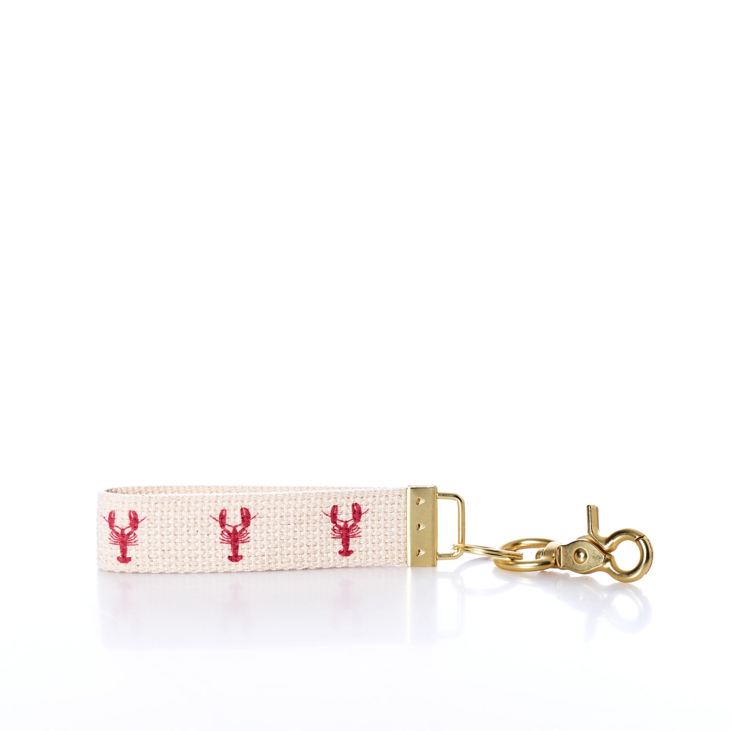 The Rustic Marlin - Keychain Maine Lobsters from Rustic Marlin is a beige fabric bag charm keychain adorned with three small red Maine lobster designs, gold metal hardware, and a lobster clasp, shown on a white background—perfect as a charming Maine souvenir. by Sea Bags