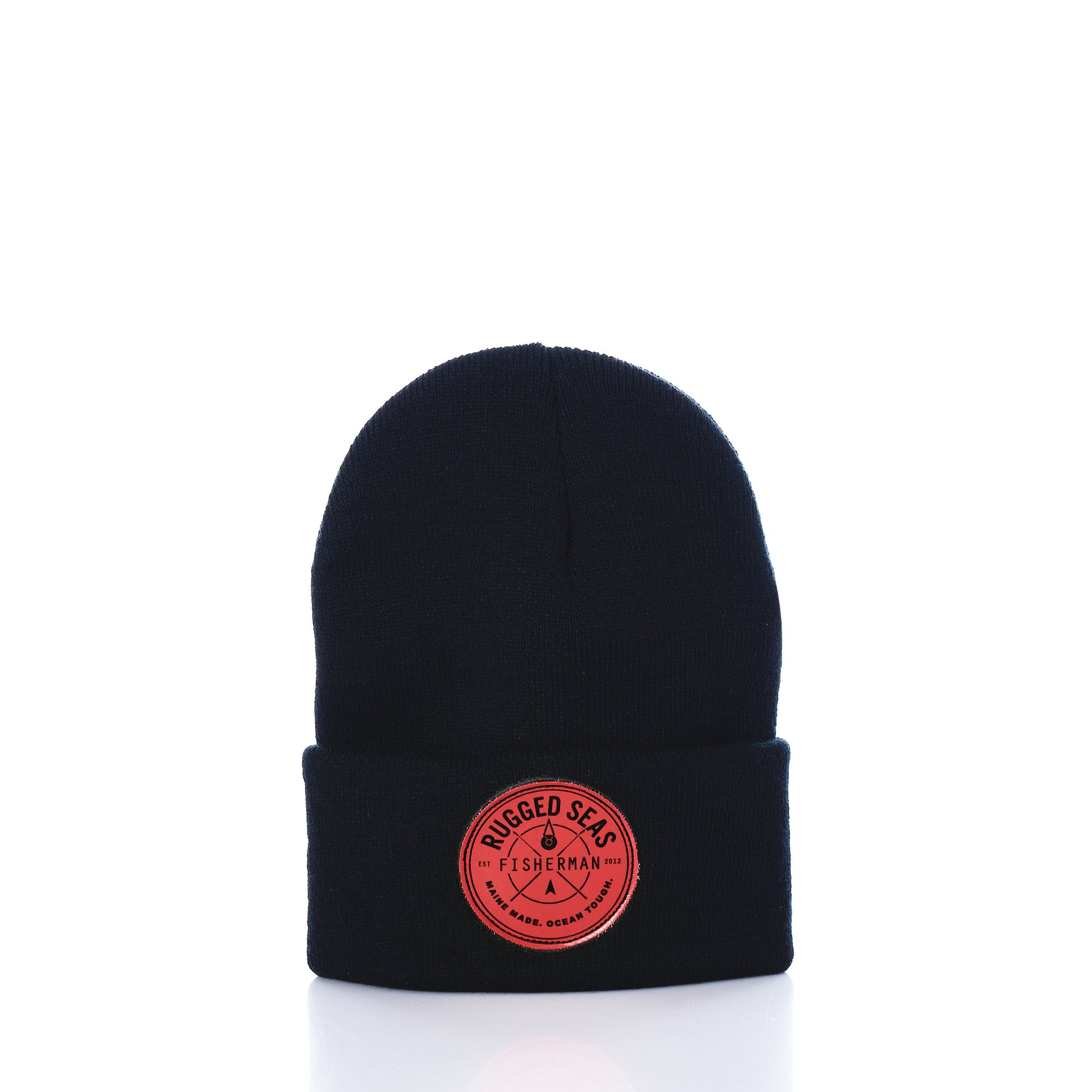 Showcased on a white background, the Rugged Seas Watch Cap by Rugged Seas is an eco-friendly black beanie crafted from recycled bib material. It features a folded brim and a circular red patch on the front that reads Rugged Seas Fisherman, making it a standout nautical statement piece. by Sea Bags