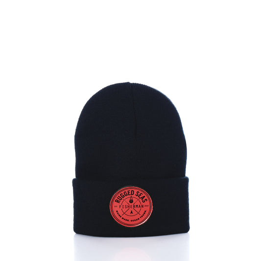 Showcased on a white background, the Rugged Seas Watch Cap by Rugged Seas is an eco-friendly black beanie crafted from recycled bib material. It features a folded brim and a circular red patch on the front that reads Rugged Seas Fisherman, making it a standout nautical statement piece. by Sea Bags