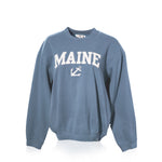 The Soft As A Grape Crewneck Pullover - Denim Maine Anchor features a denim-blue design with MAINE and a Sea Bags anchor symbol printed in white across the front, shown on a white background—a classic nod to Maine coastal style. by Sea Bags