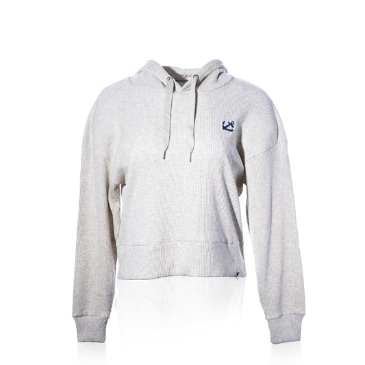 The Ribbed Hoodie Pullover - Oatmeal Anchor by Soft As A Grape features a light oatmeal ribbed texture, drawstrings, and a small navy anchor logo on the left chest. Displayed on a plain white background, this coastal style pullover offers a relaxed yet refined look that’s perfect for layering throughout the year. by Sea Bags