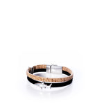 The Classic Cork Bracelet - Shark on Black by Elisabetta Studio showcases a black Portuguese cork band, accented with an antique silver shark charm and a modern magnetic clasp, beautifully presented against a white background. by Sea Bags