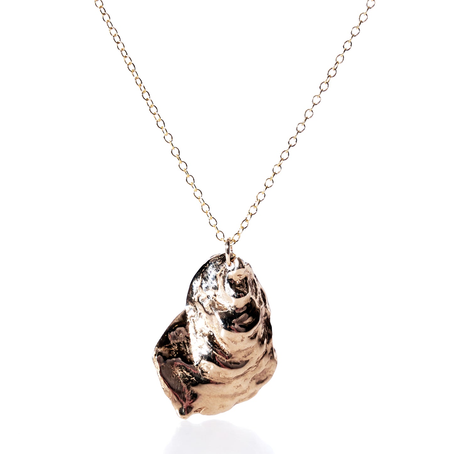 Pendant Necklace - Large Oyster Bronze by Maine Yoga Jewelry features a polished, sculptural oyster shell pendant on a gold chain, elegantly displayed against a white background—an ideal statement piece of coastal jewelry for those seeking a bold look. by Sea Bags