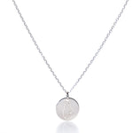 Showcased on a white background, the Pendant Necklace - Silver Maine by Maine Yoga Jewelry features a round silver pendant engraved with an outline of the state of Maine. This elegant necklace beautifully captures the spirit and charm of New England, making it a perfect piece of coastal jewelry. by Sea Bags