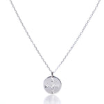 Discover the Pendant Necklace - Silver Compass Rose by Maine Yoga Jewelry, featuring a round silver pendant engraved with a compass rose showing N, S, E, and W directions. This nautical necklace is displayed on a simple chain against a white background and is proudly made in Maine. by Sea Bags