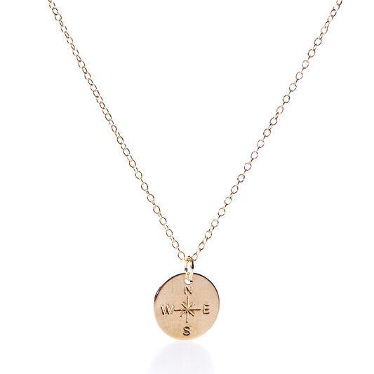 Discover the Pendant Necklace - Gold Compass Rose by Maine Yoga Jewelry, a gold chain necklace featuring a round pendant engraved with an intricate compass rose design and the letters N, E, S, and W. Thoughtfully made in Maine, this elegant nautical accessory is perfect for those drawn to adventure and timeless style. by Sea Bags