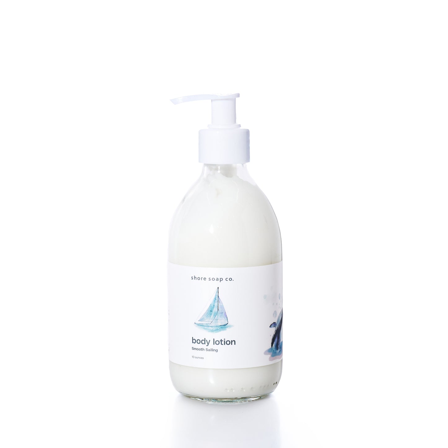 Smooth Sailing Eco-Friendly Body Lotion by Shore Soap Co is presented in a clear glass pump bottle with a white label adorned with a sailboat illustration, photographed on a white background. Ideal for sensitive skin, this natural formula delivers lasting moisture while nourishing your body. by Sea Bags