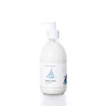 Smooth Sailing Eco-Friendly Body Lotion by Shore Soap Co is presented in a clear glass pump bottle with a white label adorned with a sailboat illustration, photographed on a white background. Ideal for sensitive skin, this natural formula delivers lasting moisture while nourishing your body. by Sea Bags