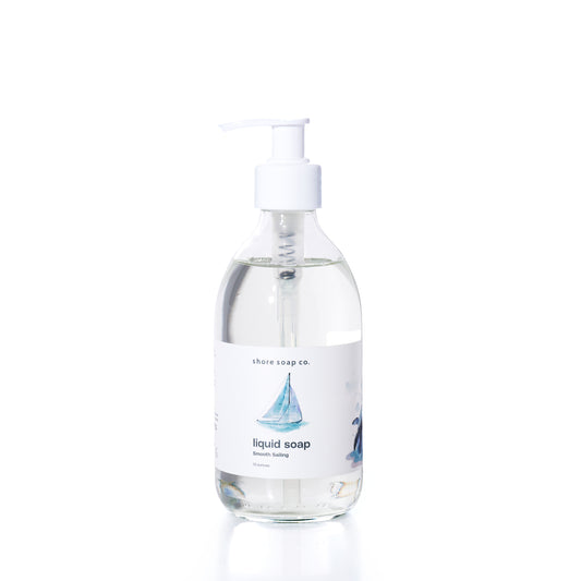 Smooth Sailing Eco-Friendly Liquid Soap by Shore Soap Co comes in a pump bottle featuring an illustration of a sailboat on the label. This gentle, pH-balanced formula is kind to skin, making it perfect for everyday use. by Sea Bags