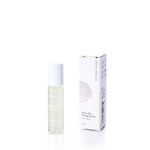 A roll-on fragrance bottle stands beside its box, labeled “Shore Soap Co. Warm Sand Eco-Friendly Roll-On Fragrance, 10ml,” featuring a seashell graphic on the packaging. This alcohol-free roll-on fragrance provides a refreshing and convenient way to experience your favorite scent wherever you go. by Sea Bags