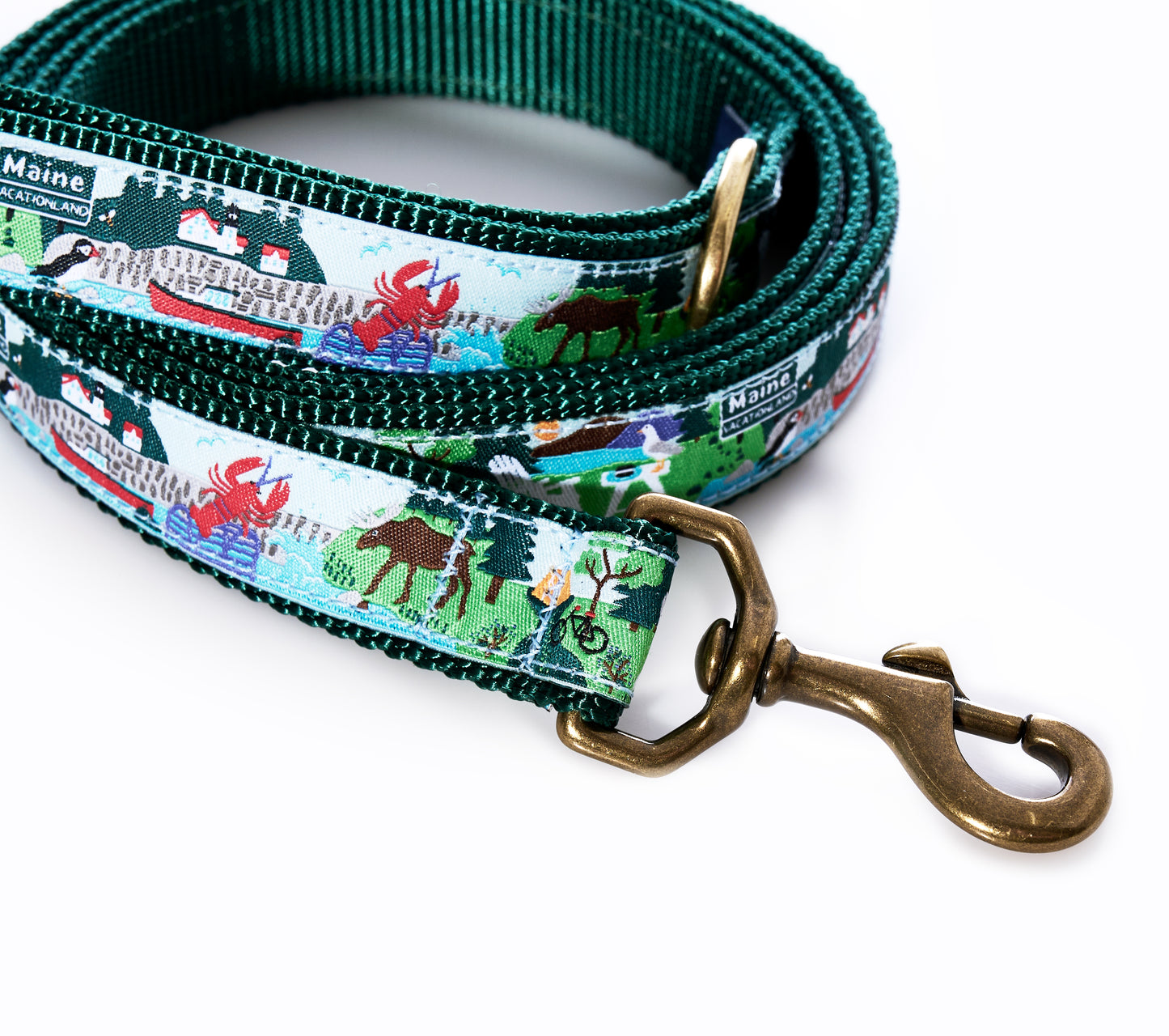 The Vacationland Dog Leash by Belted Cow features a green and white Maine-themed design on heavy-duty nylon, decorated with illustrated dogs, people, and trees, and finished with a brass clasp and an L.L.Bean Maine label. by Sea Bags
