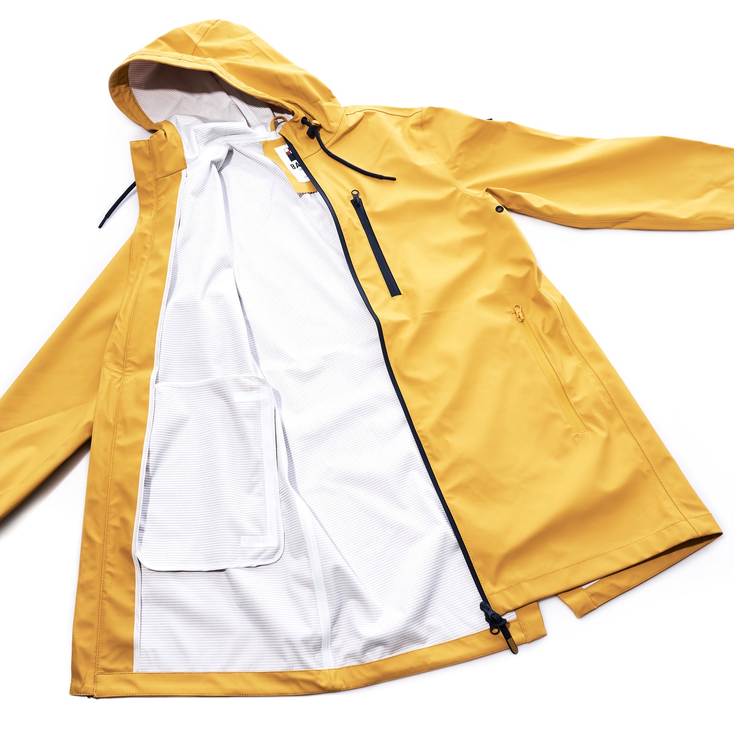 The Harborside Waterproof Raincoat - Yellow by Batela USA Inc is displayed laid flat and unzipped, showcasing its white mesh lining and convenient interior pocket. This unisex raincoat features a lightweight, waterproof shell to provide reliable protection in wet weather. by Sea Bags