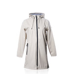 Harborside Waterproof Raincoat - Moonstruck by true: This long beige unisex raincoat features a hood, black zipper, and convenient side pockets, showcased against a white background. Its waterproof shell offers reliable protection from the elements, while the interior is lined with a chic black and white striped pattern.