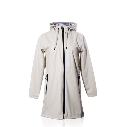 Harborside Waterproof Raincoat - Moonstruck by true: This long beige unisex raincoat features a hood, black zipper, and convenient side pockets, showcased against a white background. Its waterproof shell offers reliable protection from the elements, while the interior is lined with a chic black and white striped pattern.