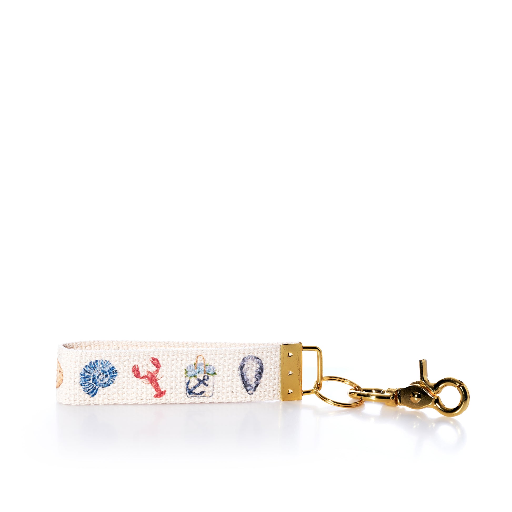 Showcasing embroidered nautical motifs—including a shell, lobster, anchor, and seashell—on a white woven background with gold hardware, the Rustic Marlin Keychain - Summer Icons by Rustic Marlin is a charming accessory that makes the perfect bag charm or souvenir for your coastal adventures. by Sea Bags