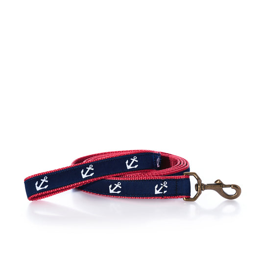 The Sea Bags Anchor Print Dog Leash by Belted Cow is a tough, heavy-duty nylon leash in navy blue and red with white anchor patterns and a sturdy metal clasp, shown coiled on a white background.