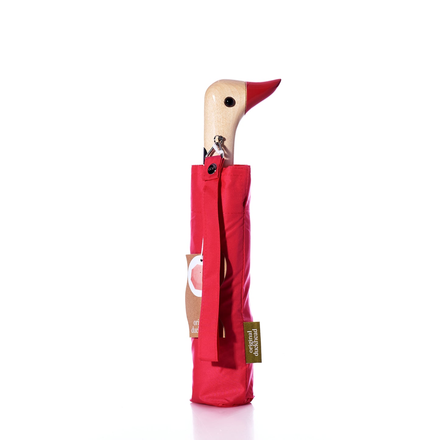 Original Duck Head Umbrella - Red by Original Duckhead stands upright against a white background, featuring a wooden handle shaped like a duck’s head with a red beak. This compact and functional umbrella combines playful design with practicality—perfect for brightening up rainy days. by Sea Bags