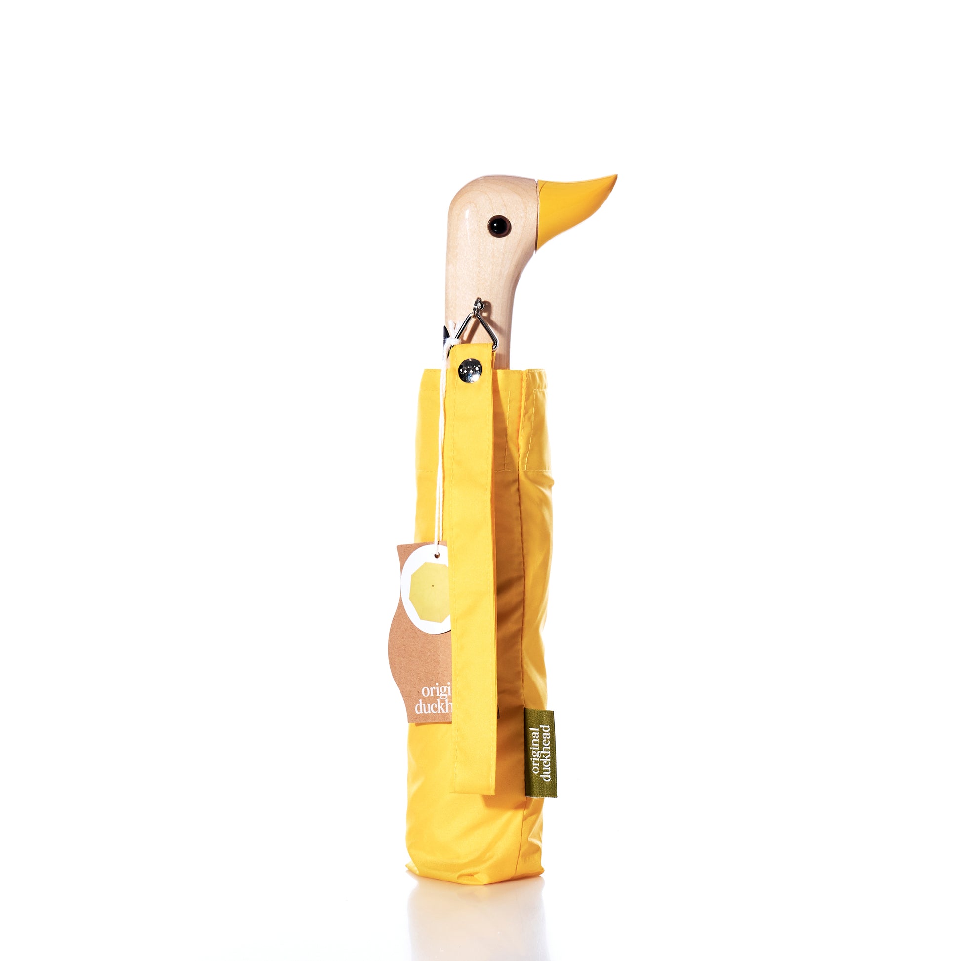 The Original Duck Head Umbrella - Yellow by ODH Limited t/a Original Duckhead stands upright closed, featuring a yellow canopy and a wooden handle shaped like a duck’s head, with tags attached on a white background. This PFAS free recycled umbrella is both stylish and eco-friendly. by Sea Bags
