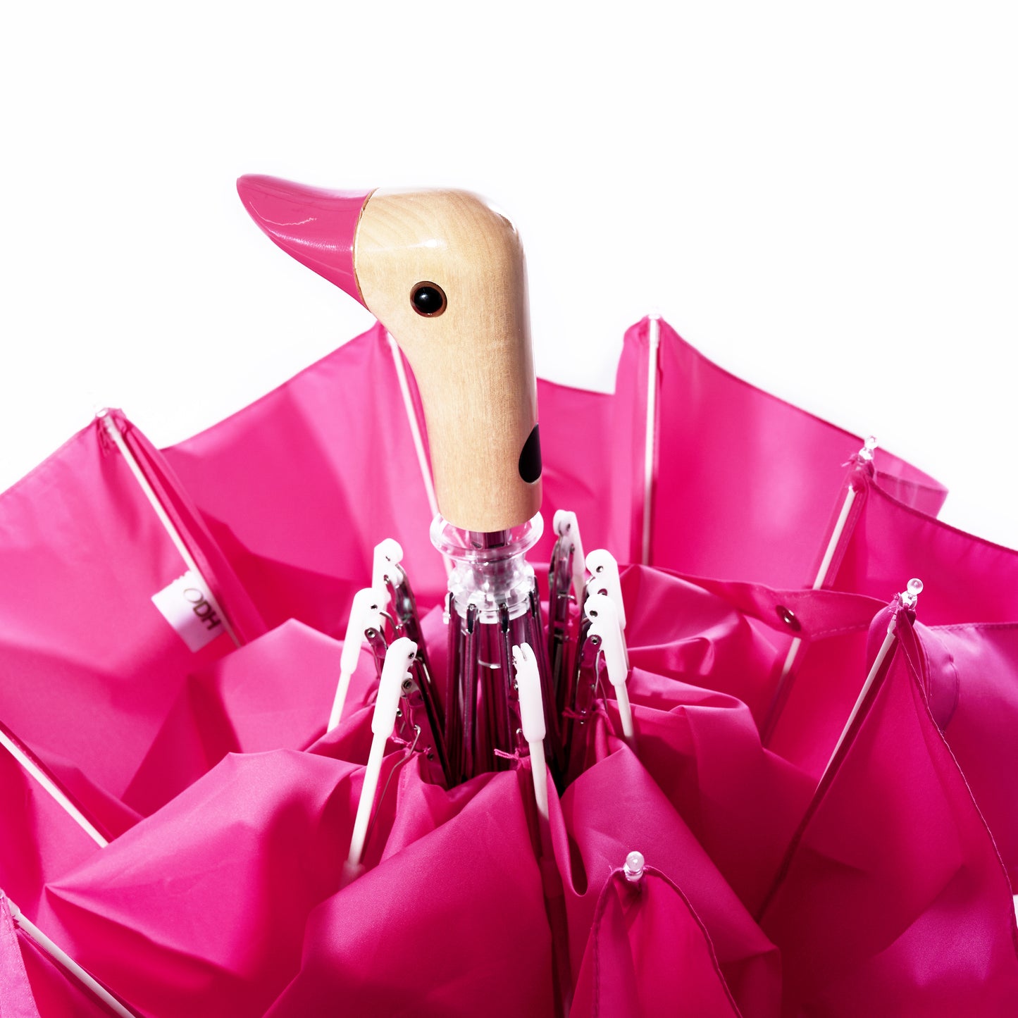 An upright Original Duck Head Umbrella - Pink by ODH Limited t/a Original Duckhead, with its signature duck head-shaped handle, is set against a white background. This durable umbrella blends playful design with practical reliability. by Sea Bags