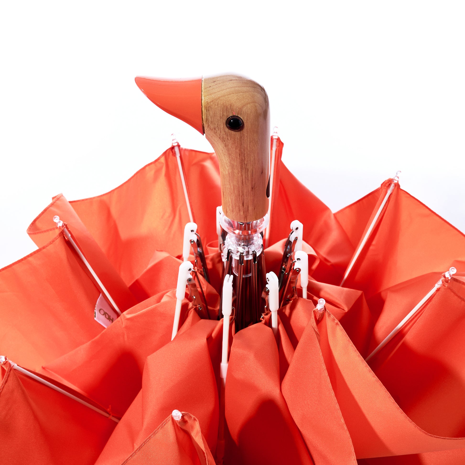 The Original Duck Head Umbrella - Papaya by ODH Limited t/a Original Duckhead features a vibrant orange canopy and a signature wooden handle crafted in the shape of a duck’s head. Partially open with its fabric gathered around the handle, this wind-resistant umbrella blends playful design and durable construction for dependable weather protection.