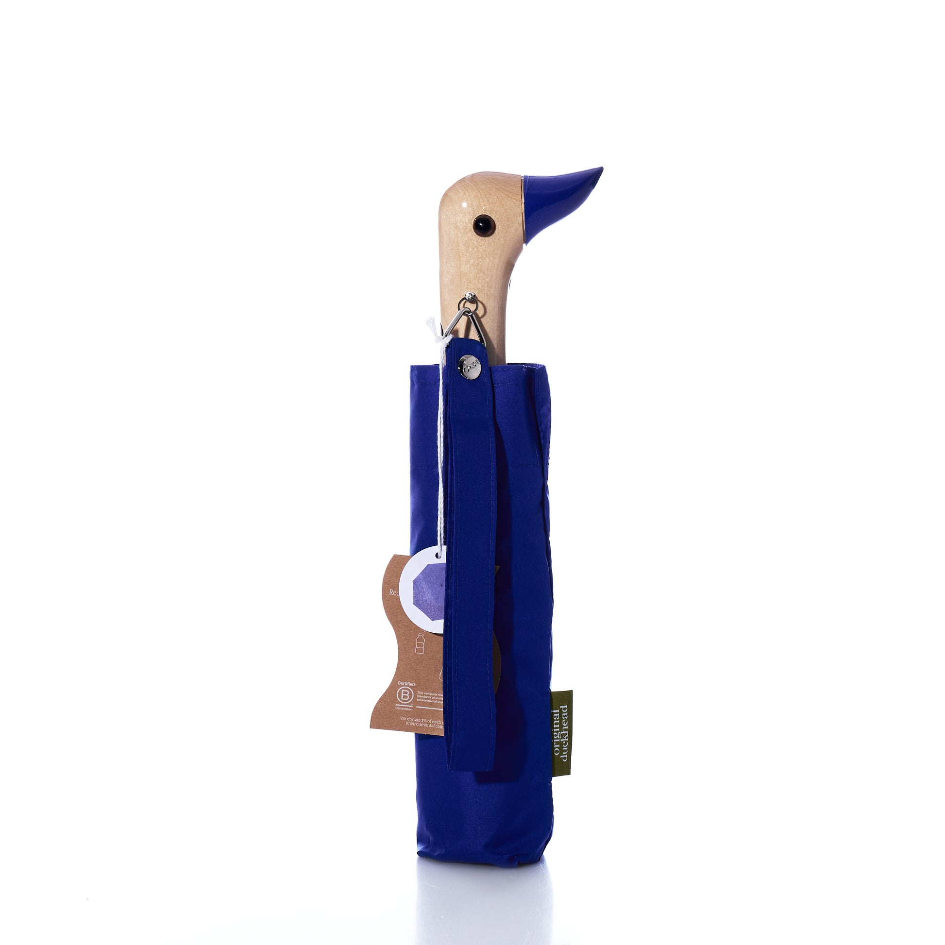 Original Duck Head Umbrella - Cobalt Blue by ODH Limited t/a Original Duckhead, featuring a charming wooden duck-head handle partially sheathed in matching cobalt blue fabric, with product tags attached and set against a white background. This wind-resistant umbrella is thoughtfully crafted for both durability and style.