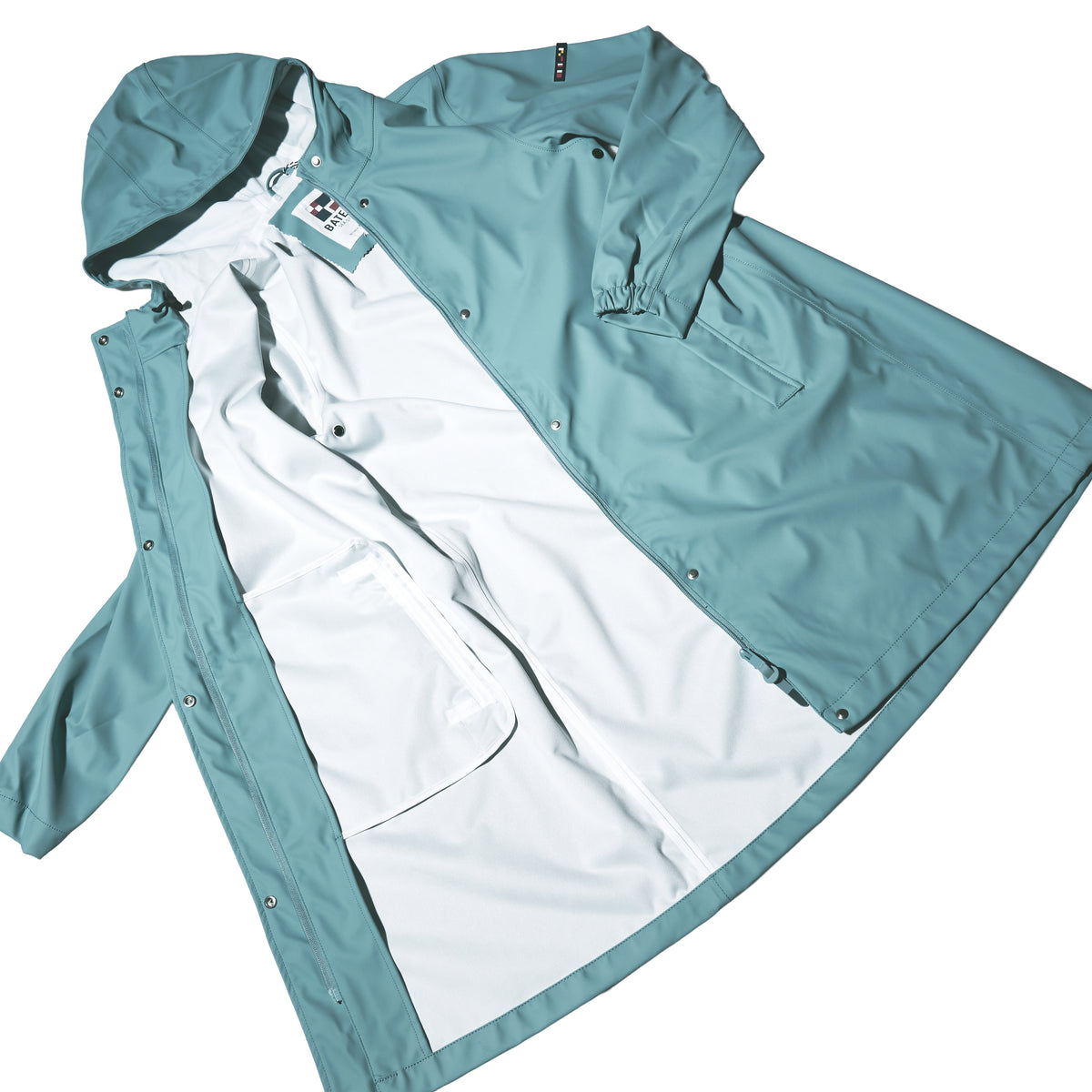 Harborside Waterproof Raincoat - Tourmaline by Batela USA Inc shown open on a white background, featuring white lining, inner pockets, and snap button closures.