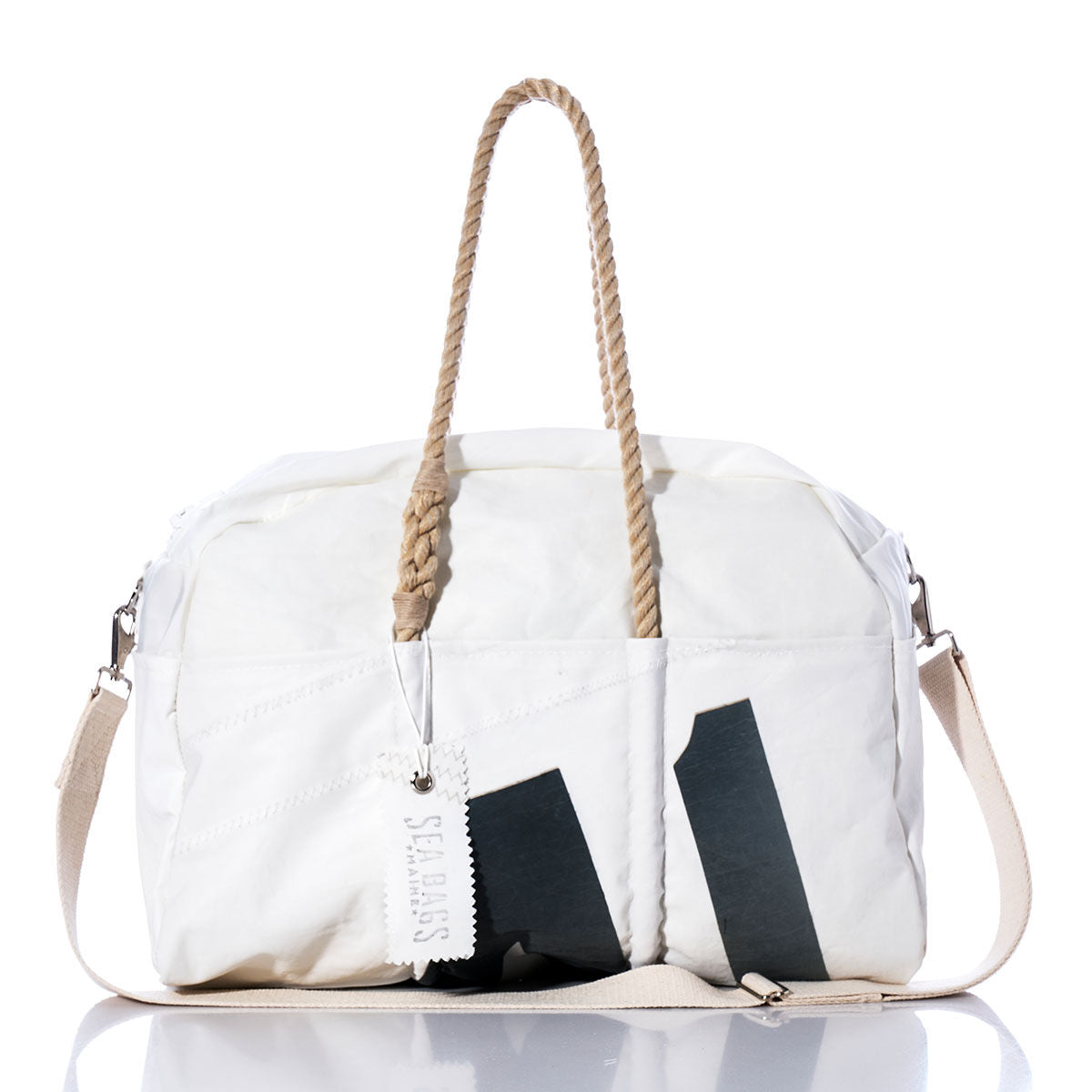 The Vintage Black 41 Weekender by Sea Bags features a white exterior with rope handles, a beige shoulder strap, and a rectangular “Sea Bags” tag. Bold vintage black graphic accents and a zippered top make this the perfect bag for your next getaway. by Sea Bags