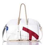 The Sea Bags Vintage Harbor 20 Weekender features a white exterior with tan rope handles, a cream shoulder strap, and striking red and blue graphic accents—making it the perfect choice for a vintage-inspired harbor getaway or as a stylish weekender bag. An attached tag reading seabags.lifepletes the look. by Sea Bags