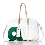 The Sea Bags Vintage Green 8 Weekender is a white and green getaway bag designed with hemp handles, a detachable shoulder strap, and a signature Sea Bags tag. Displayed on a reflective surface, this stylish and functional duffel is perfect for your next adventure. by Sea Bags