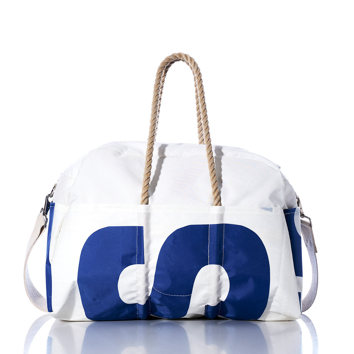 Introducing the Sea Bags Vintage US Weekender—a white duffel bag with bold blue lettering, hemp handles, and a detachable shoulder strap, displayed on a reflective surface. The perfect choice for your next getaway. by Sea Bags