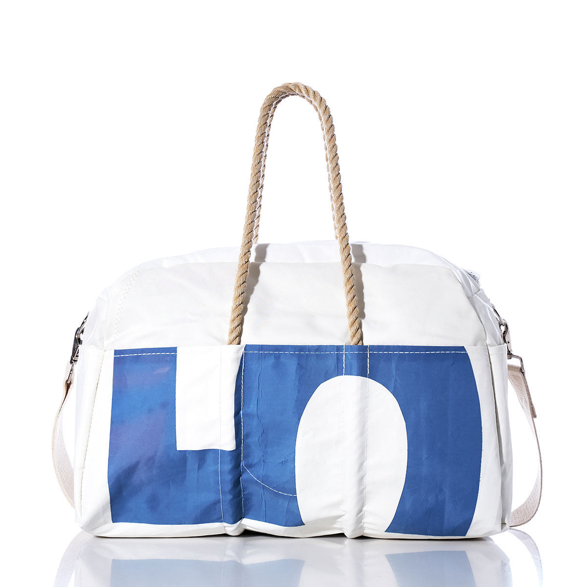 The Sea Bags Vintage 45 Weekender features a crisp white exterior with bold blue lettering, rope handles, and a convenient side strap. Photographed on a reflective white background, this stylish bag combines modern design elements with vintage charm—making it the perfect companion for your next getaway. by Sea Bags