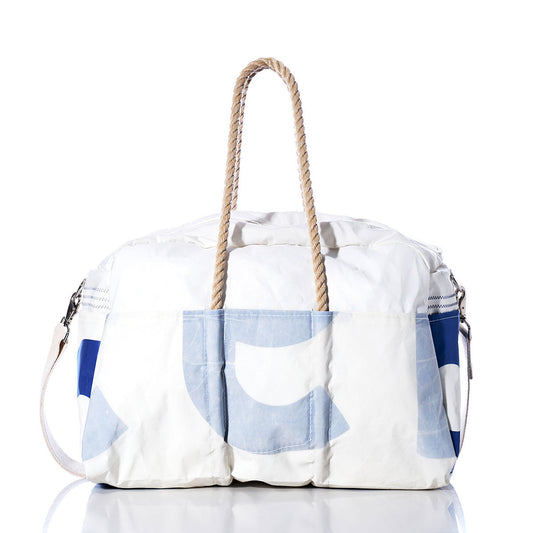 The Sea Bags Vintage US Weekender, featuring white and blue hues with rope handles and a convenient shoulder strap, is displayed on a reflective surface against a white background—bringing vintage charm to your next getaway. by Sea Bags