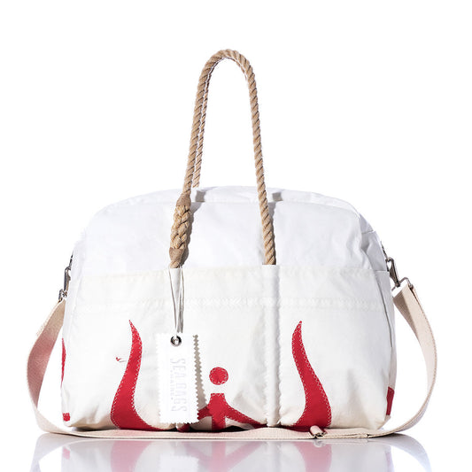 The Vintage Ericson 23 Weekender by Sea Bags features a white exterior with beige hemp handles, a matching beige shoulder strap, striking red accents, and a white tag—displayed on a reflective surface against a white background, this stylish bag is perfect for getaways. by Sea Bags