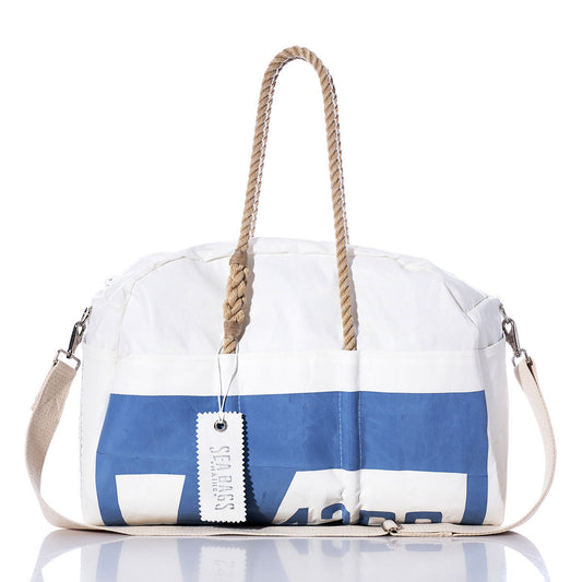 The Sea Bags Vintage Tartan 4300 Weekender is a white and blue duffel bag featuring sturdy hemp handles, a detachable shoulder strap, and a rectangular SEABAGS tag attached to one handle—an ideal getaway bag inspired by classic vintage style. by Sea Bags