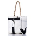 The Vintage Typhoon Medium Tote by Sea Bags, handcrafted in Maine from recycled sailcloth, features black accents, sturdy rope handles, and a signature SEABAGS tag. This white tote bag is shown on a white background. by Sea Bags