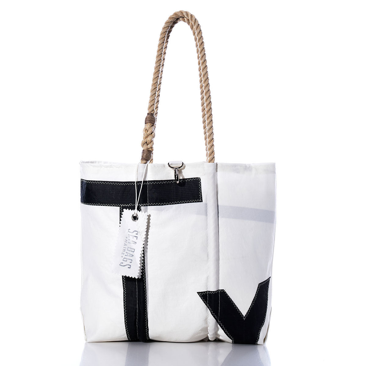 The Vintage Typhoon Medium Tote by Sea Bags, handcrafted in Maine from recycled sailcloth, features black accents, sturdy rope handles, and a signature SEABAGS tag. This white tote bag is shown on a white background. by Sea Bags