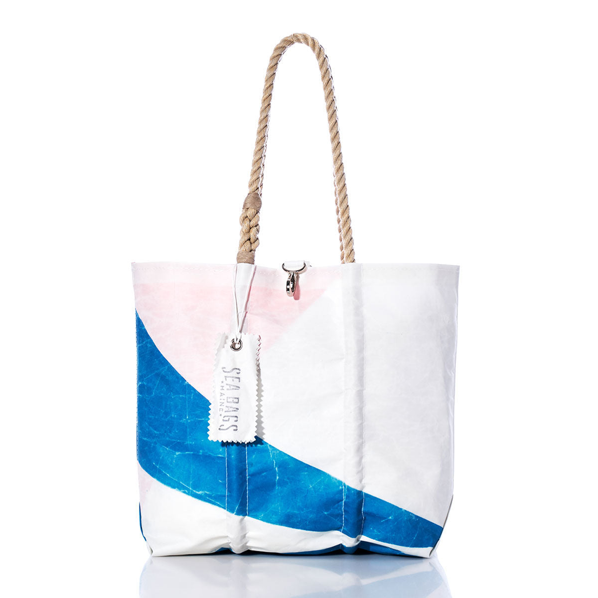 The Sea Bags Vintage Etchells Medium Tote is a handcrafted white sailcloth bag adorned with a bold blue and pink diagonal pattern, complete with durable rope handles and a SEA BAGS label. This Maine-made tote is elegantly displayed against a white background. by Sea Bags