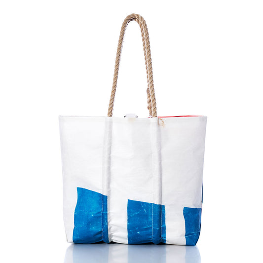 The Sea Bags Vintage Etchells Medium Tote is a handmade white sailcloth tote bag crafted from recycled sails, featuring blue geometric accents and sturdy rope handles. Set against a plain white background, this durable Maine-made bag embodies timeless nautical style. by Sea Bags